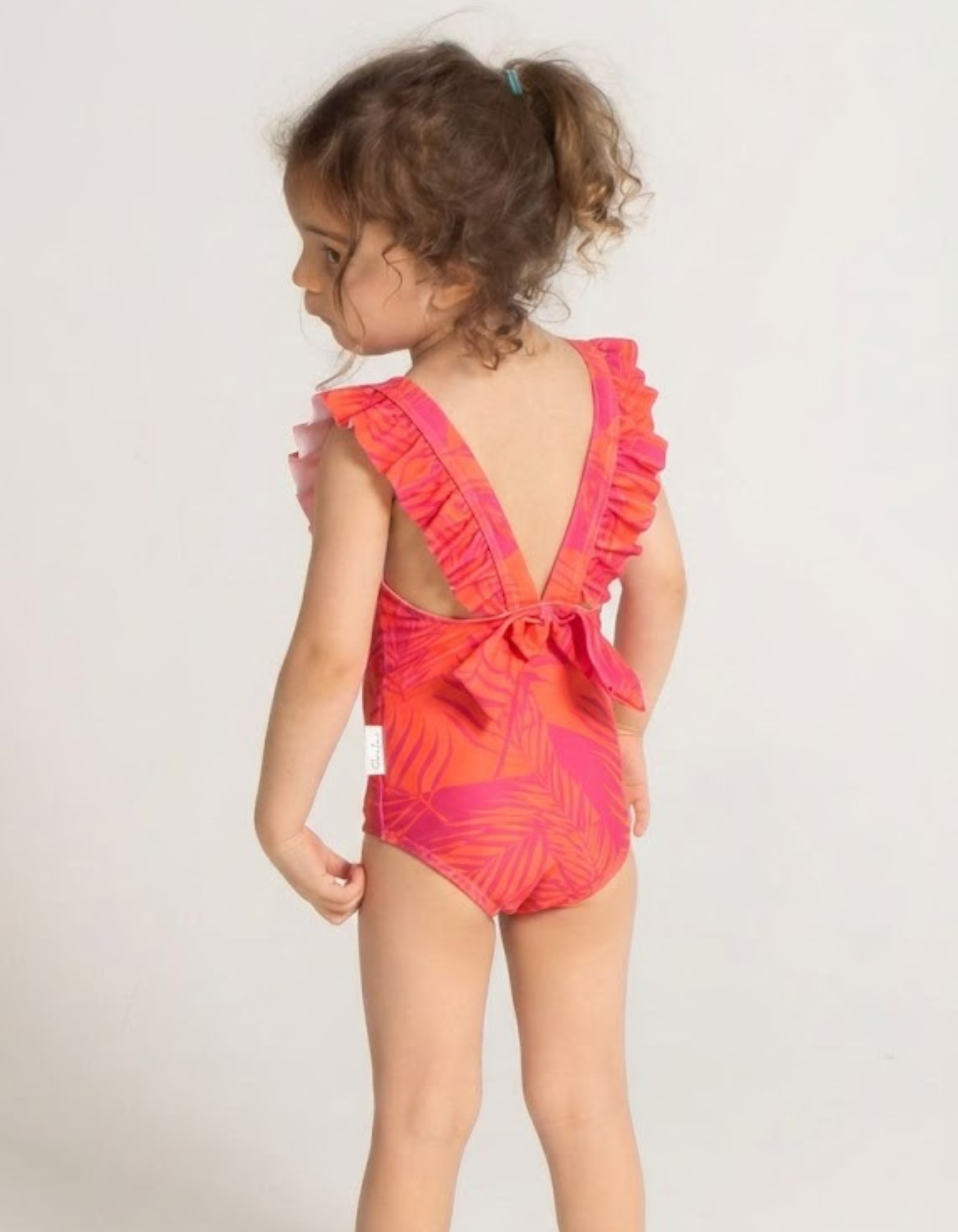 Aperol Palm Girls Ruffle Swimsuit, back view. Sustainable girls swimwear.