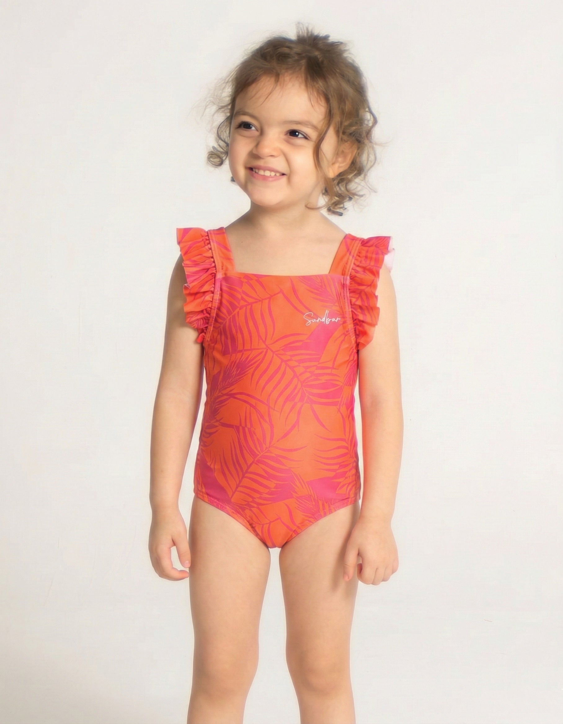 Aperol Palm Girls Ruffle Swimsuit, front view. Sustainable girls swimwear.