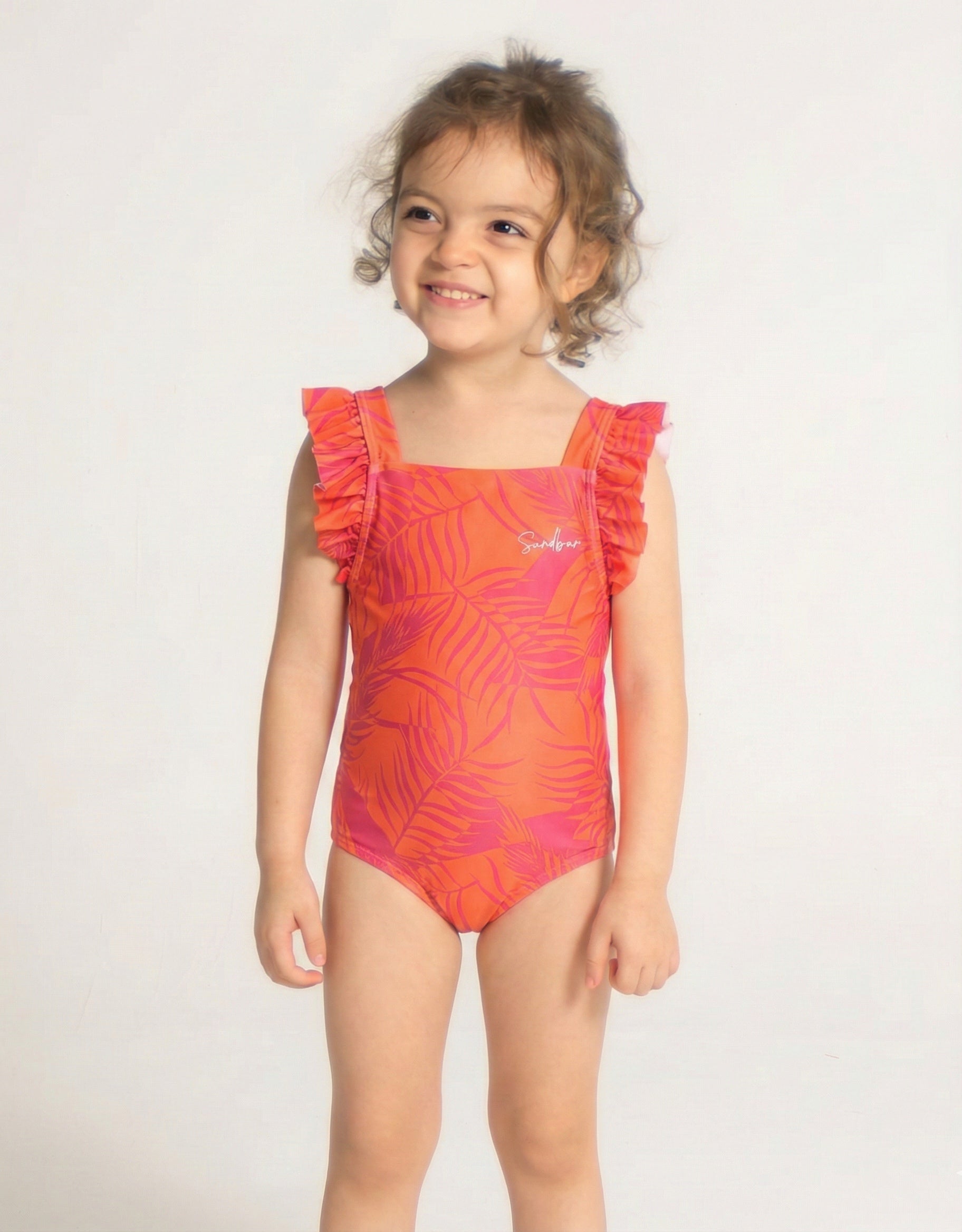 Aperol Palm Girls Ruffle Swimsuit, front view. Sustainable girls swimwear.