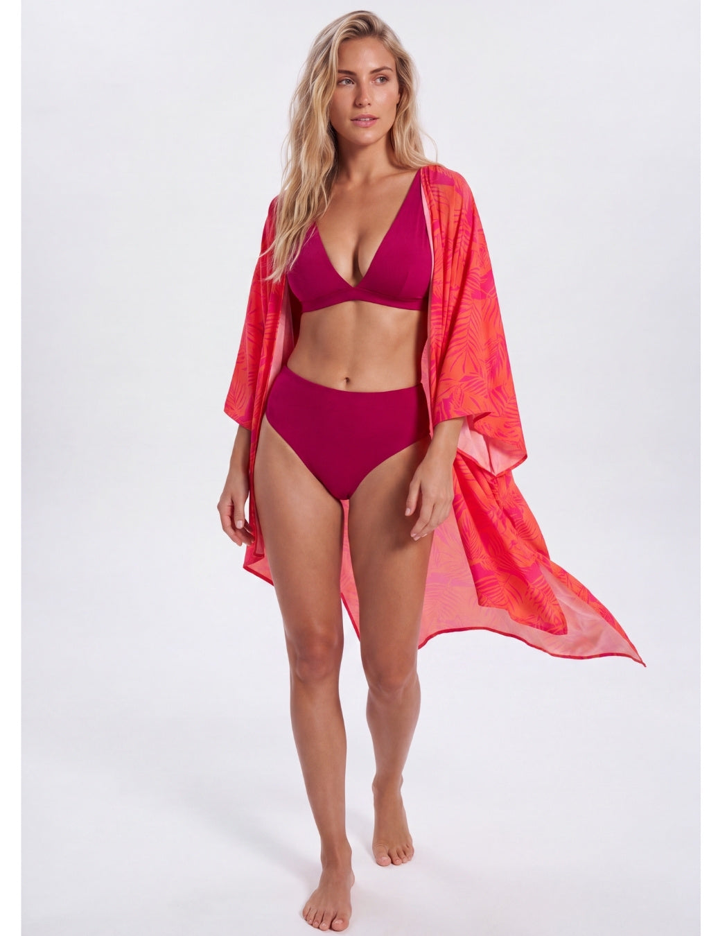 Aperol Palm caftan worn over a plum bikini, front view of the coral and pink print