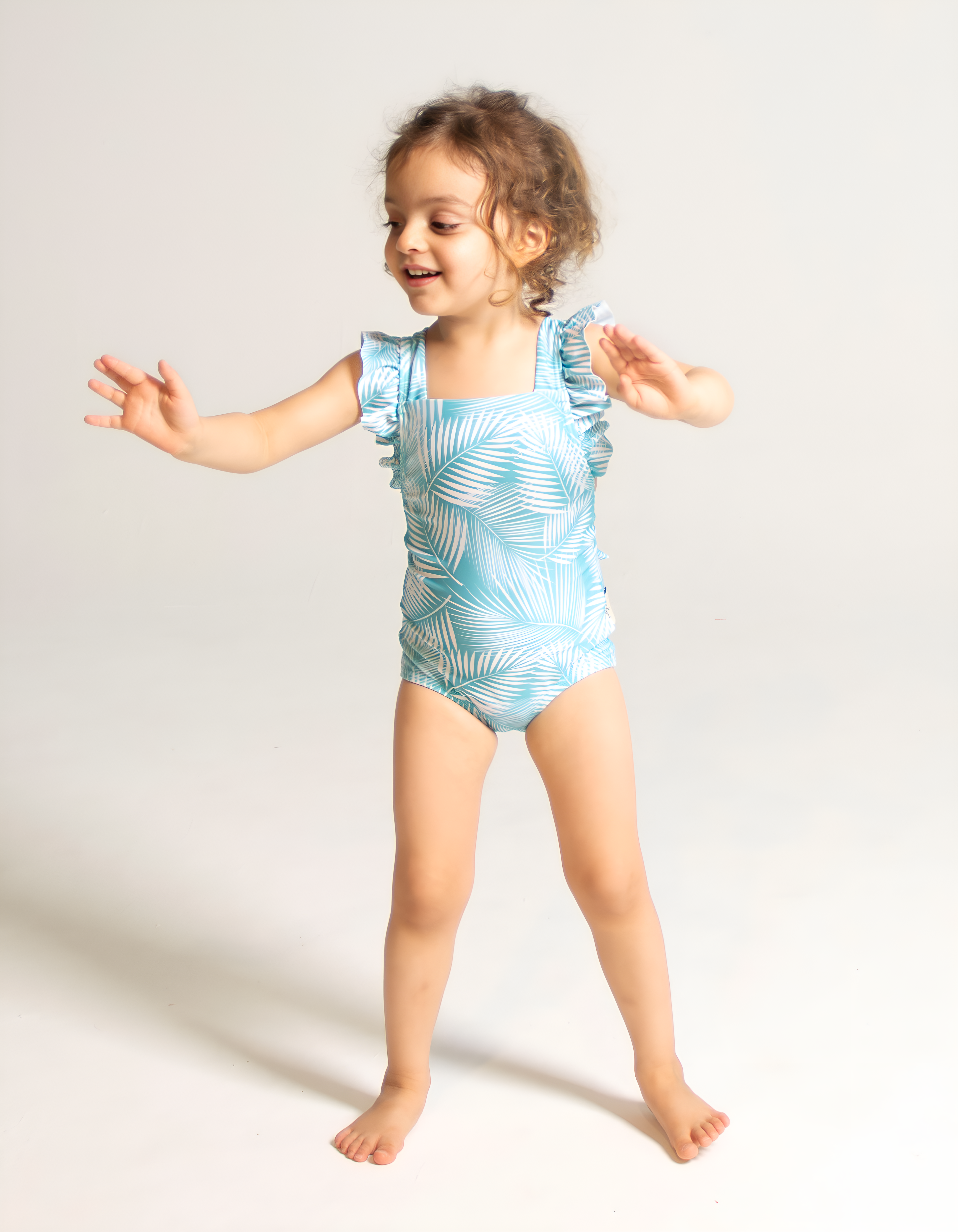 Green Fern Girls Ruffle Swimsuit, front view. Sustainable girls swimwear.