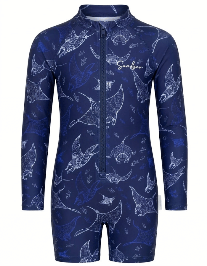 A long-sleeve one-piece swim coverall with a full front zipper and stand-up collar, featuring an all-over white line-art print of manta rays on a dark navy blue background. The brand name 'Sandys' is printed in white script on the left chest.