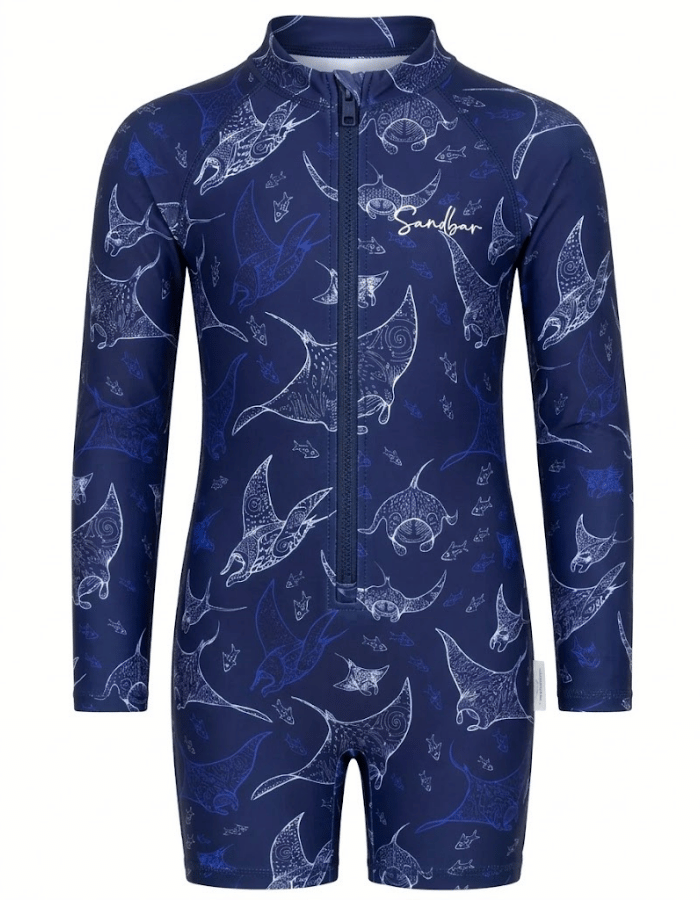 A long-sleeve one-piece swim coverall with a full front zipper and stand-up collar, featuring an all-over white line-art print of manta rays on a dark navy blue background. The brand name 'Sandys' is printed in white script on the left chest.