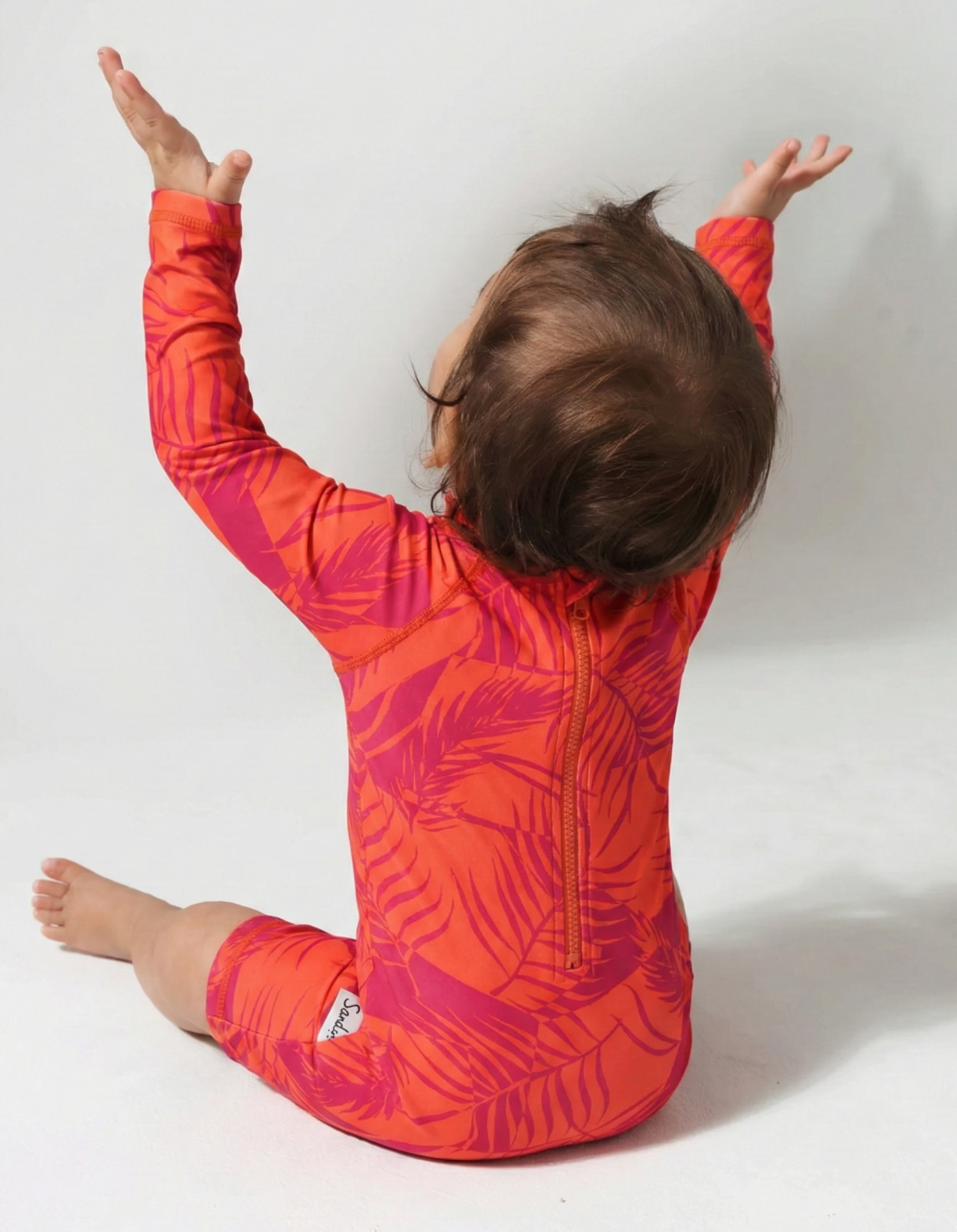 Aperol Palm Baby Swimsuit, back view. Sustainable baby swimwear.