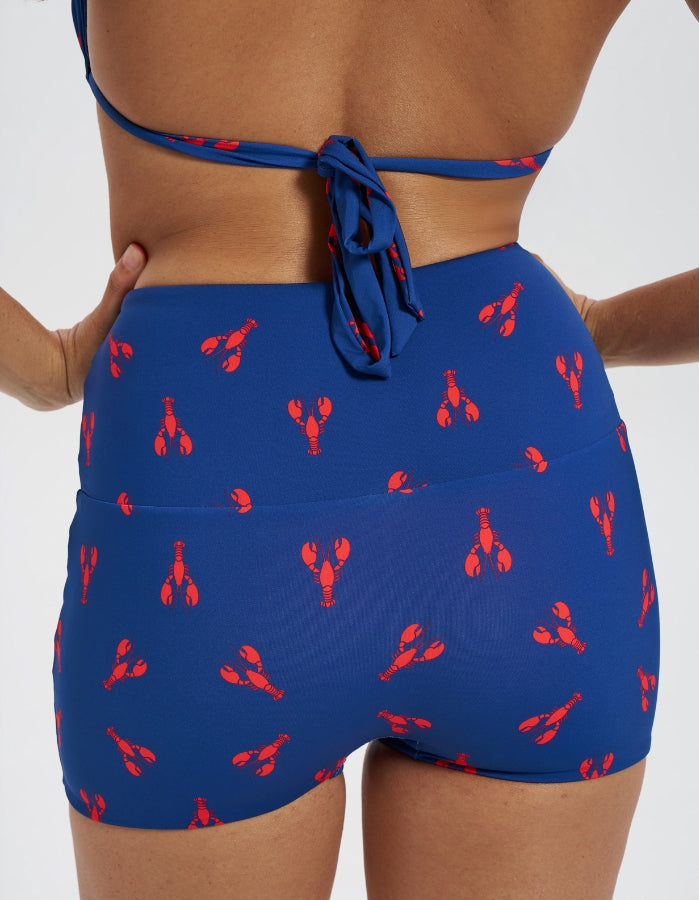 Lobster / Red Womens Reversible Swim Shorts, back view. Sustainable womens swimwear.
