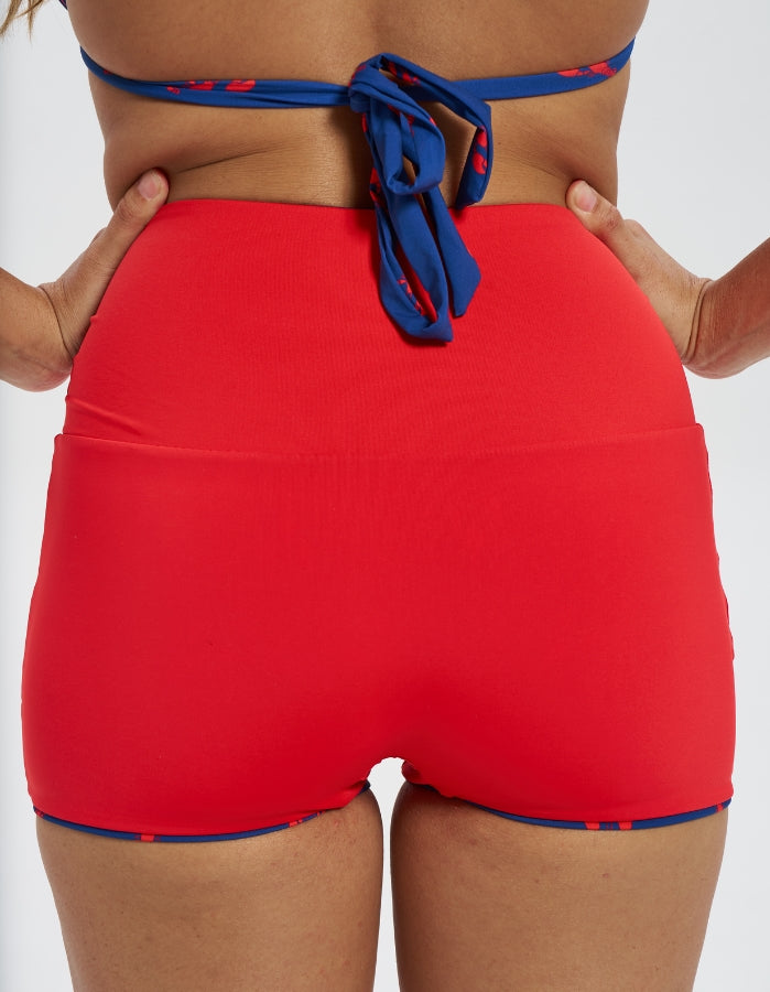 Lobster / Red Womens Reversible Swim Shorts, back view. Sustainable womens swimwear.