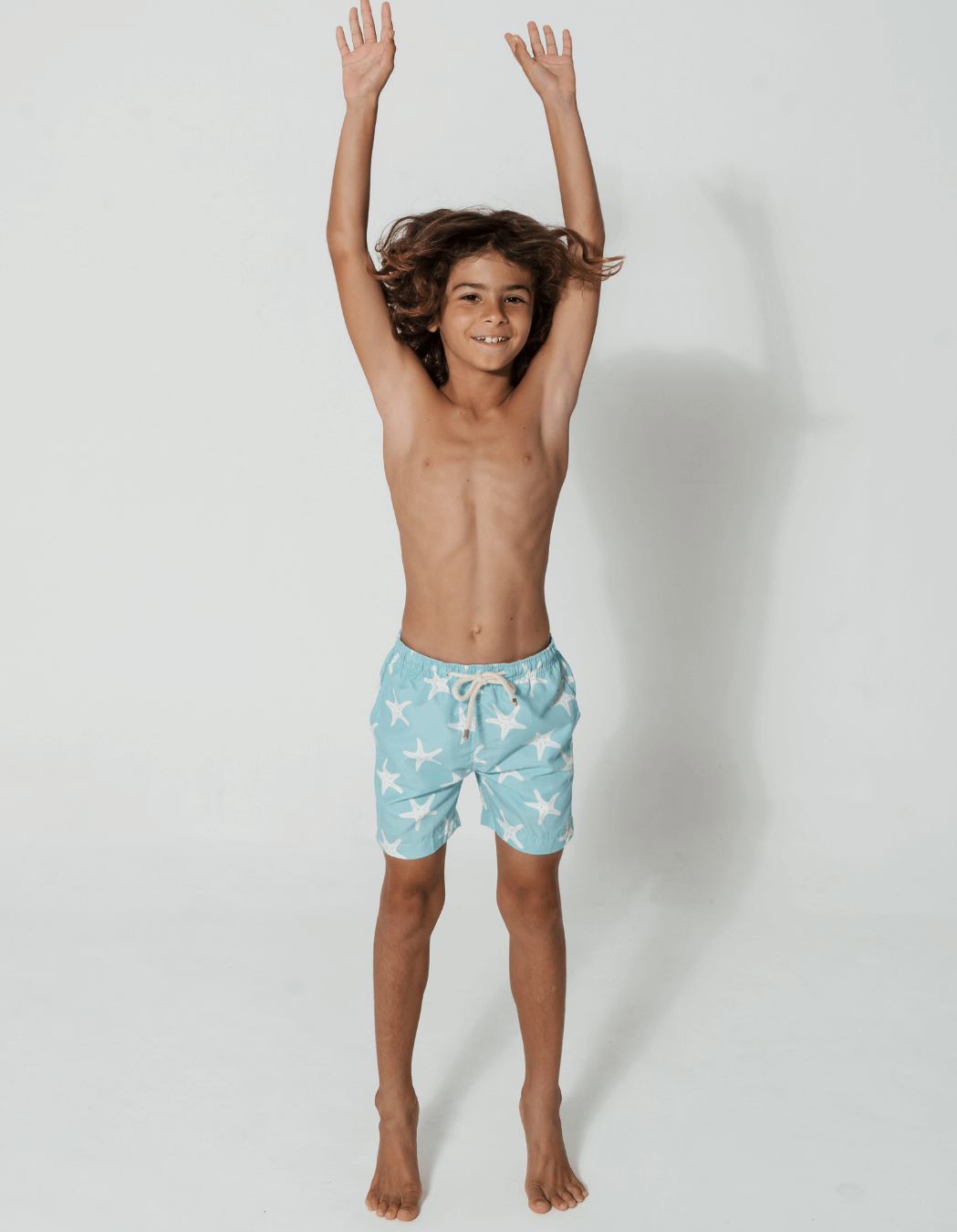 Blue Starfish Boys Swim Shorts, lifestyle shot. Sustainable boys swimwear.