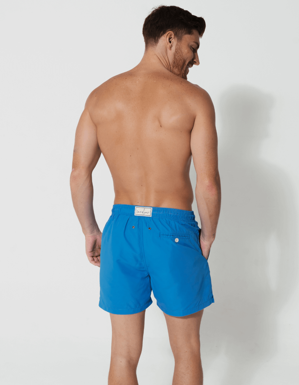 Coastal Blue Mens Swim Shorts, lifestyle shot. Sustainable mens swimwear.
