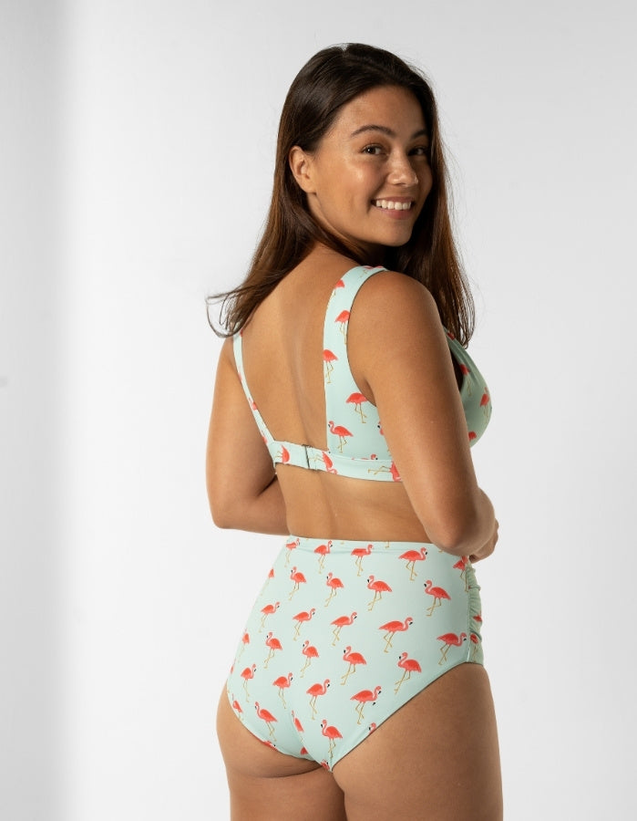 Dune – Pink Flamingo Womens Plunge Bikini Top, lifestyle shot. Sustainable womens swimwear.