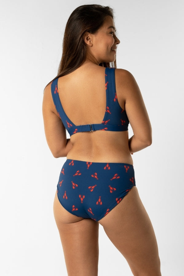 Dune – Royal Red Lobster Womens Plunge Bikini Top, lifestyle shot. Sustainable womens swimwear.