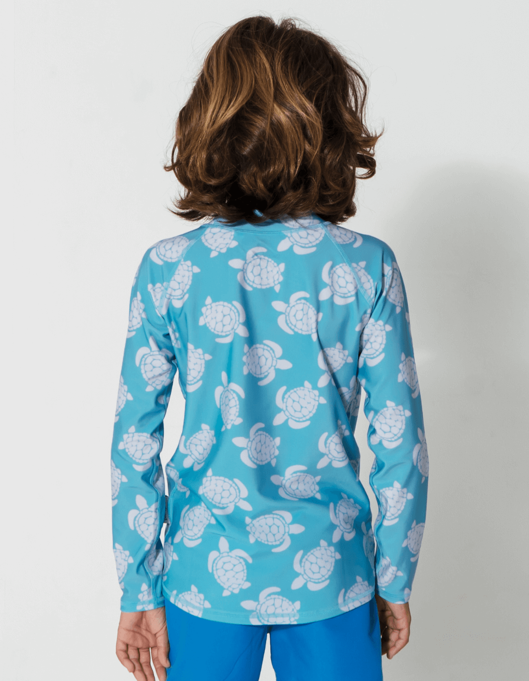 Maldives Blue Turtle Rash Guard, lifestyle shot. Kids UPF50 rash guard.