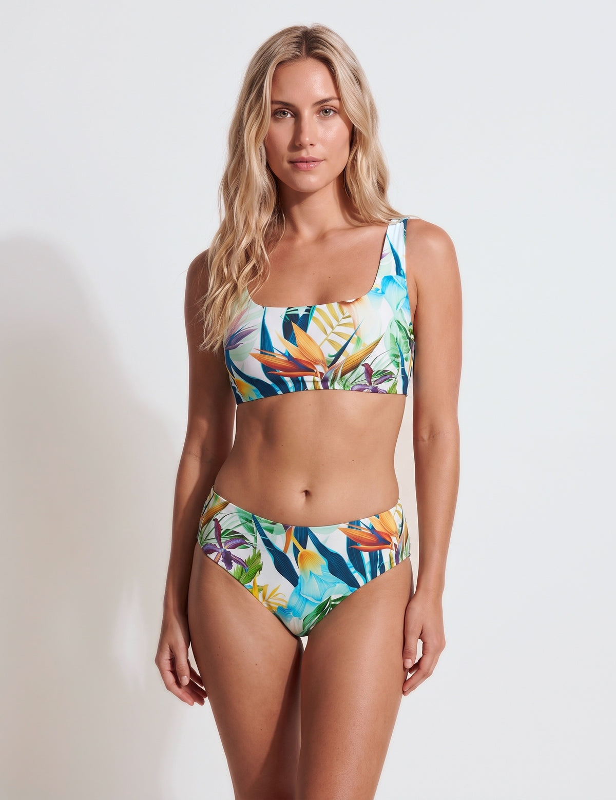 Woman wearing Mid Waist Bird of Paradise bikini bottoms with a matching top, tropical floral print, front view