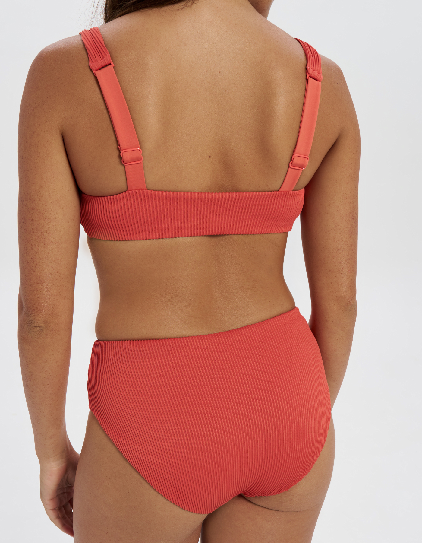 Mid Waist Coral Womens Ribbed Bikini Bottoms, back view. Sustainable womens swimwear.
