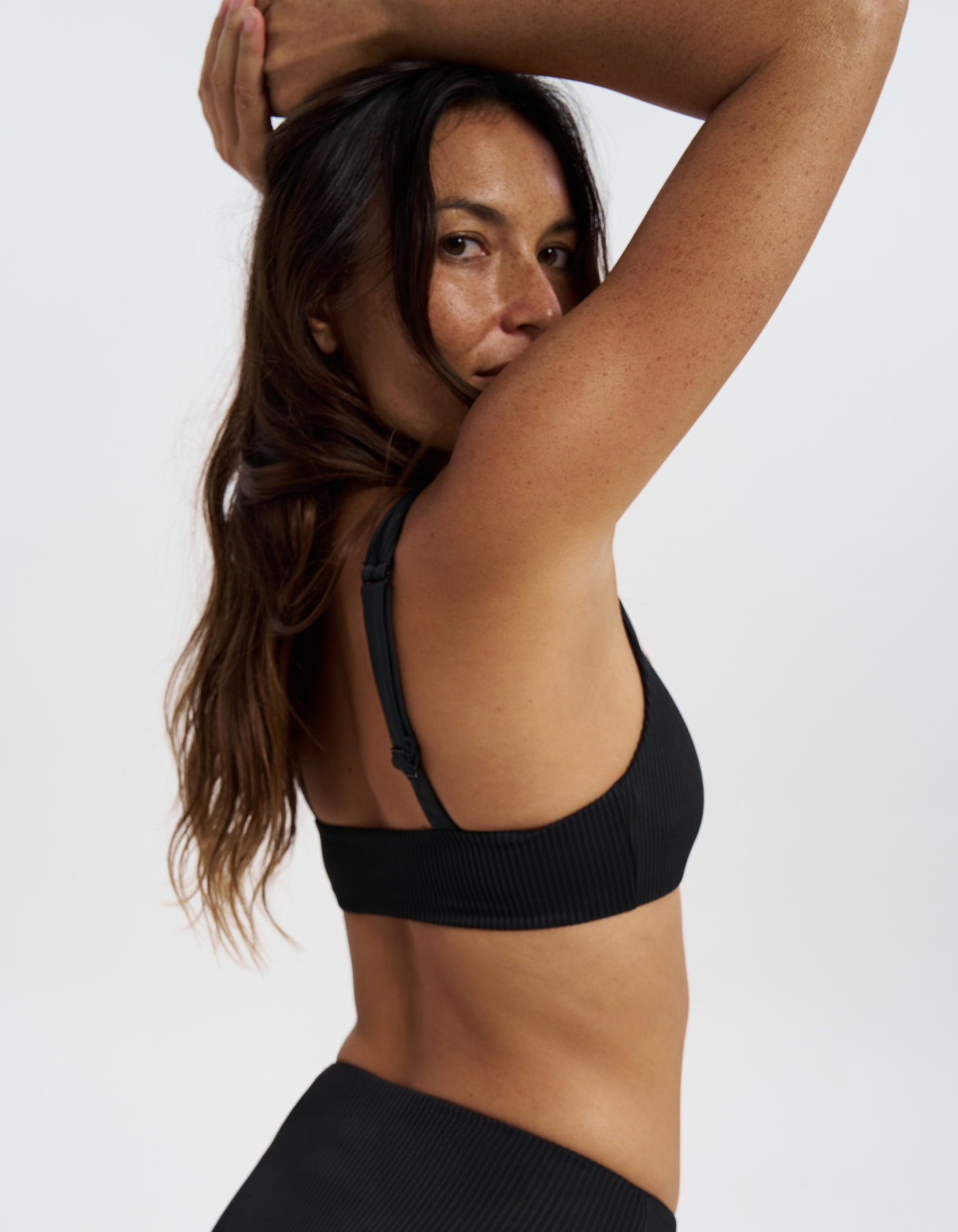 Nikoi Black Womens Ribbed Tank Bikini Top, back view. Sustainable womens swimwear.