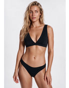 A woman modeling a black two-piece bikini set against a plain light gray studio background. Sandbar Swimwear