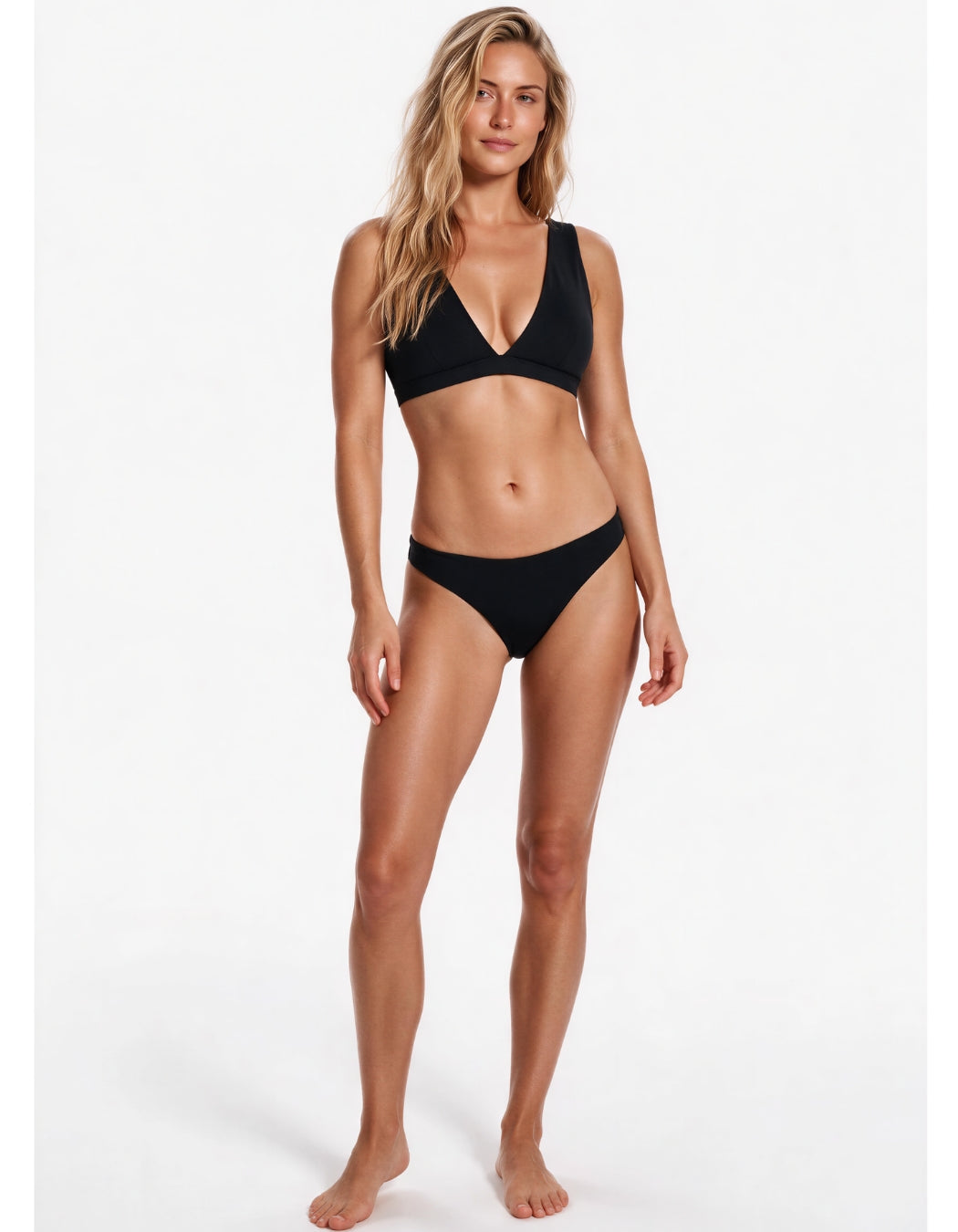 A woman modeling a black two-piece bikini against a plain white studio background. Sandbar Swimwear