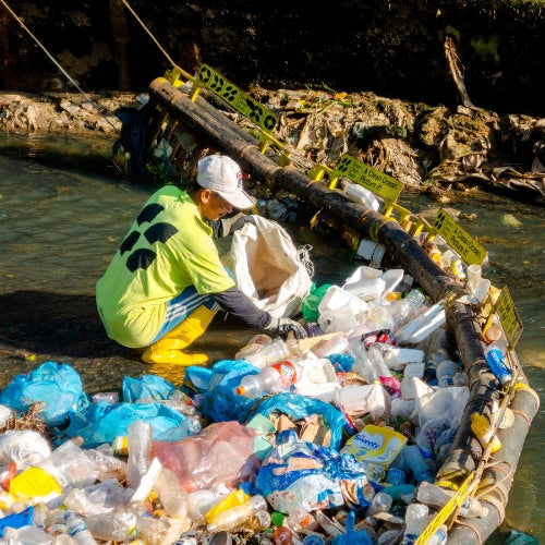 Seven Clean Seas crew sorting plastic waste collected from a river
