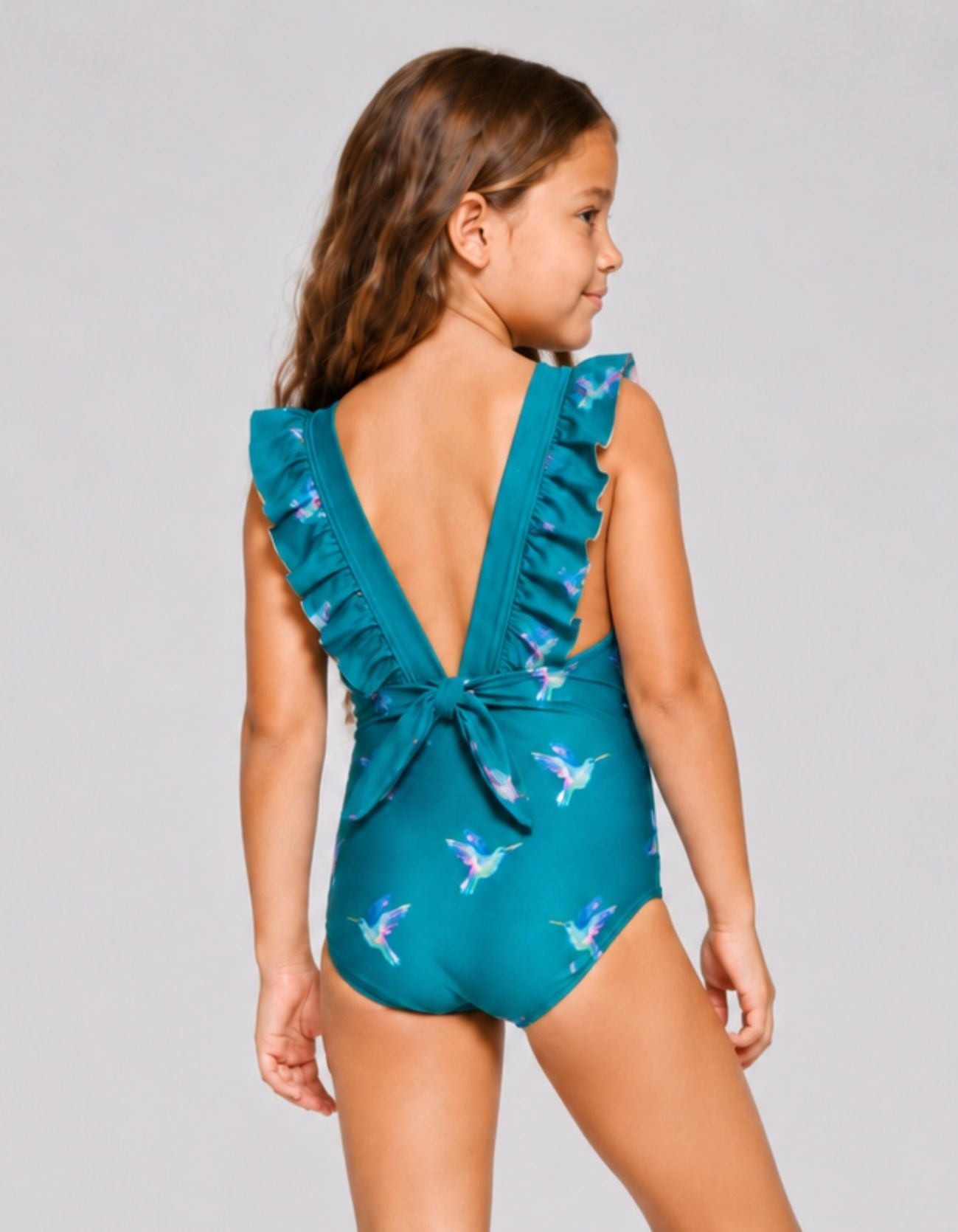 Kids teal hummingbird one-piece swimsuit with ruffle straps, back view, close