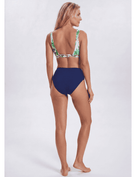 A woman modeling a two-piece bikini from the back, featuring a solid navy blue high-waisted bottom and a green tropical leaf print halter top, against a light gray studio background. Sandbar Swimwear