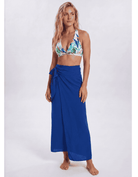 A woman modeling a royal blue wrap sarong skirt paired with a tropical print bikini top, standing against a light gray studio background. Sandbar Swimwear