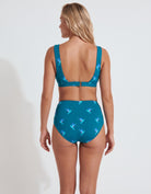 A woman shown from the back wearing a teal two-piece swimsuit with a light blue and white butterfly pattern, set against a plain white studio background.