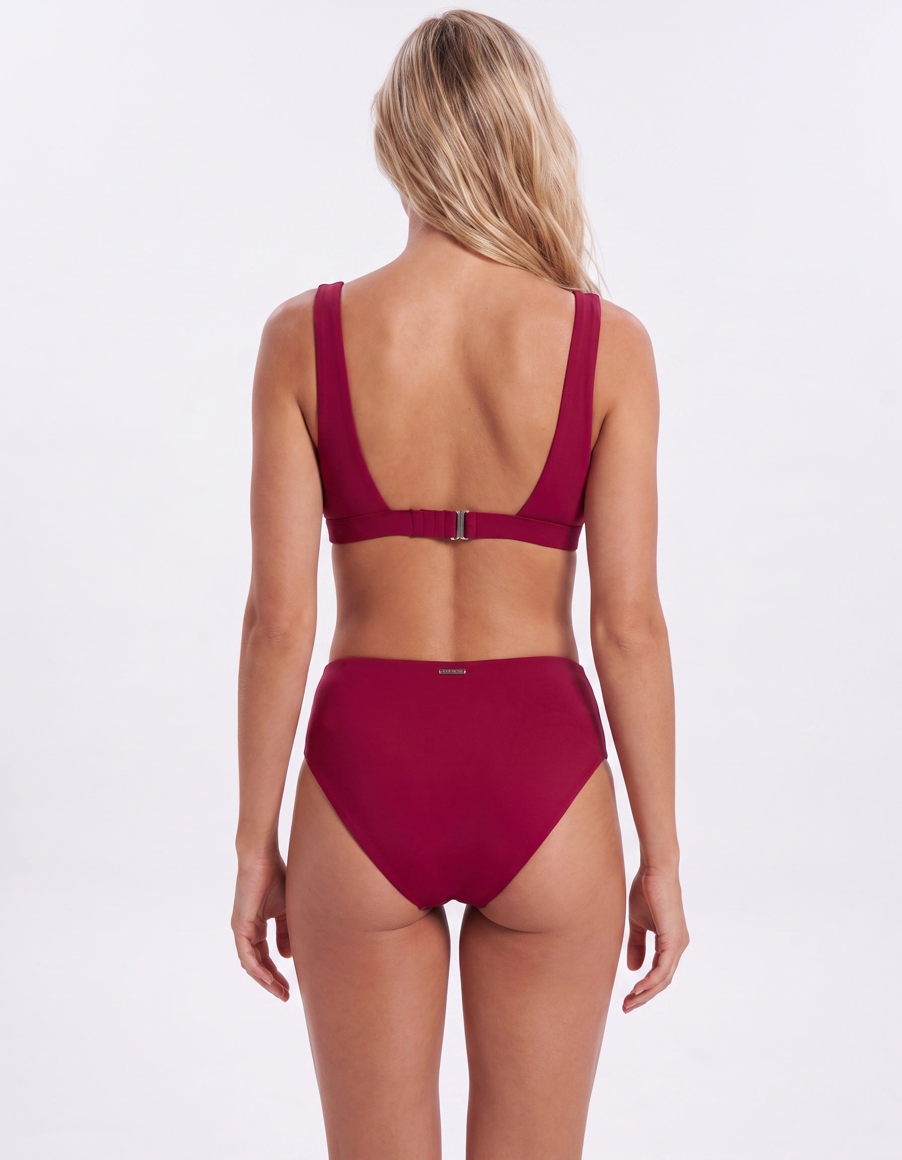 A woman shown from the back wearing a two-piece bikini in a deep burgundy or wine red color, set against a plain white studio background.